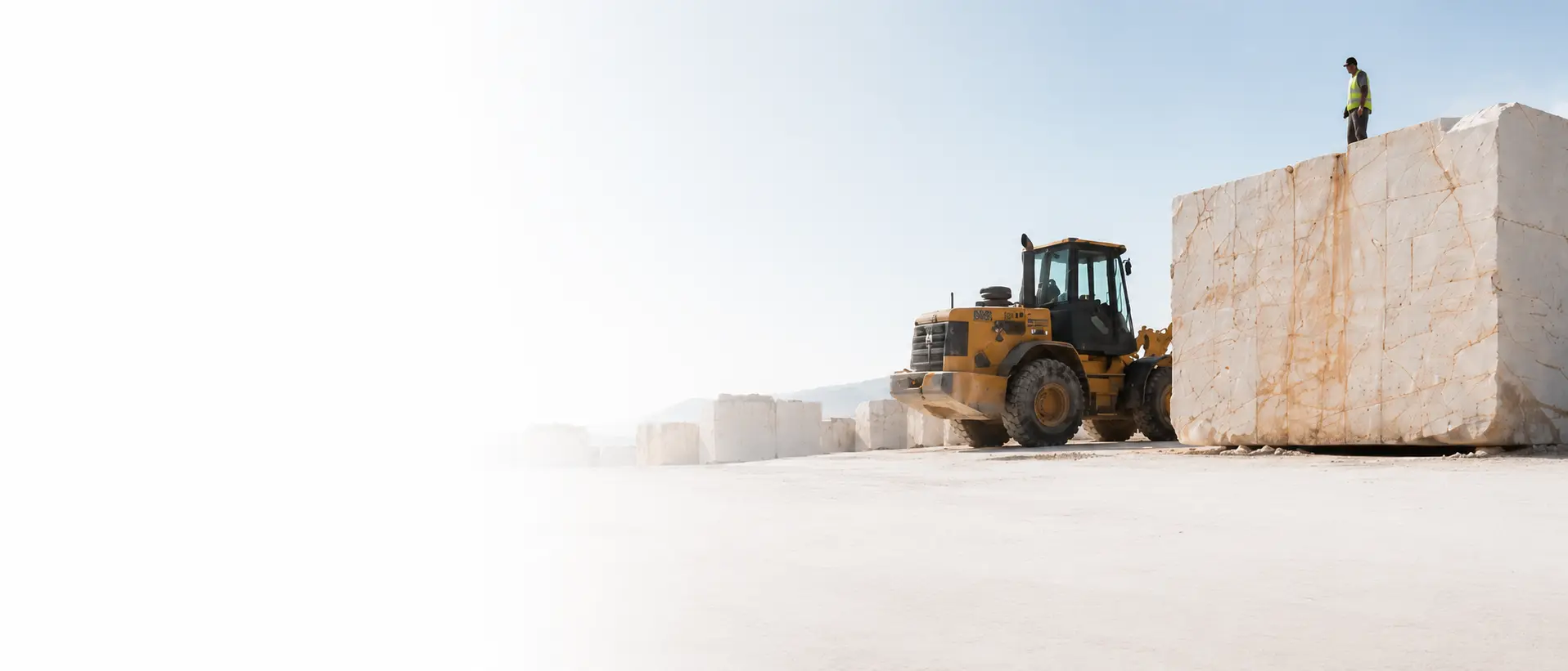 A loader lifting a marble block at the quarry